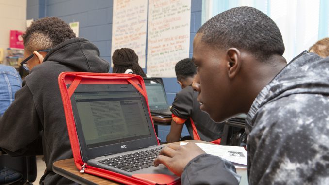 student working with laptop in classroom